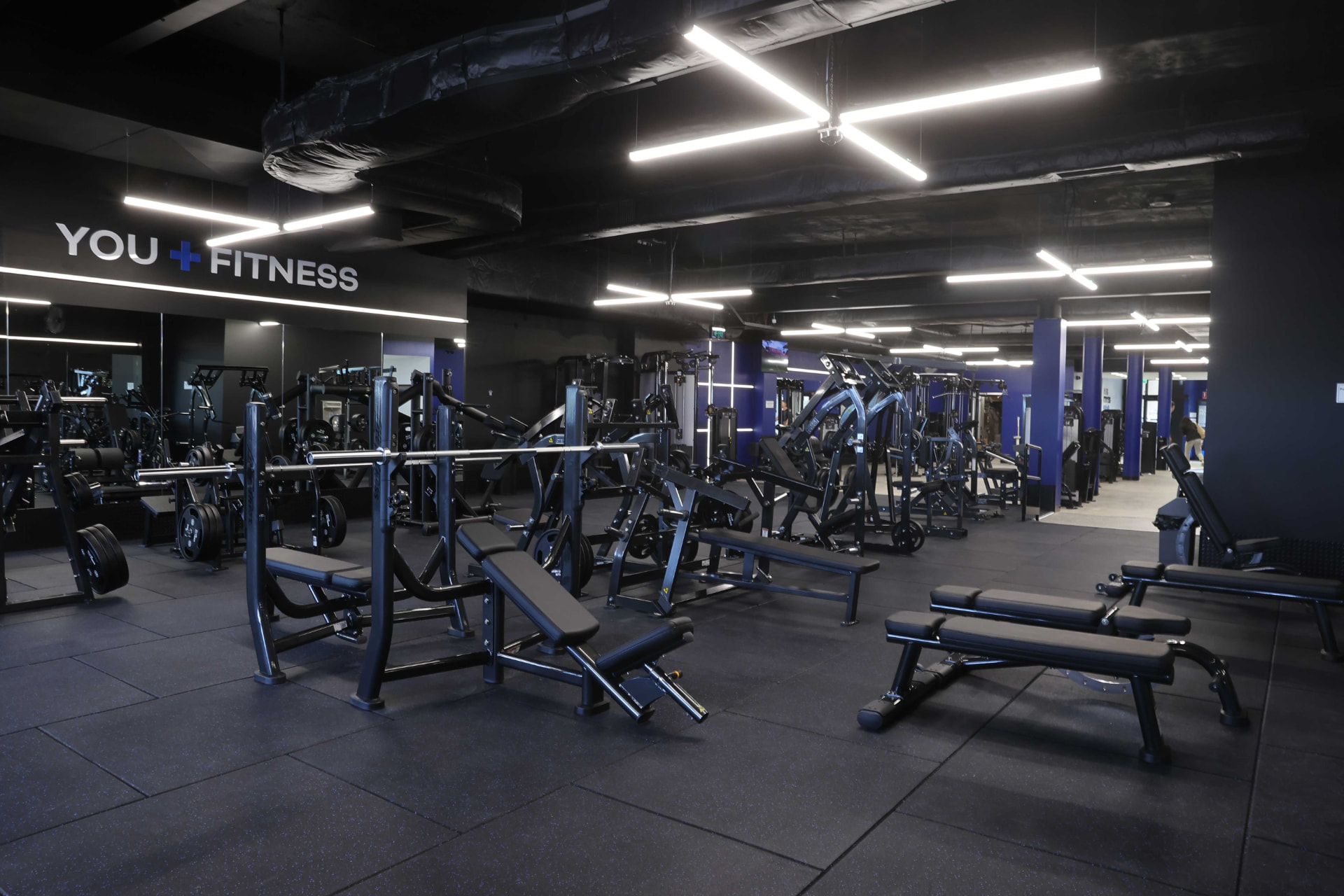 The equipment floor at Plus Fitness Gladesville, with the YOU FITNESS sign